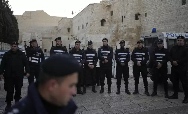 Palestinian police line up next to Church of the Nativity, traditionally believed to be the birthplace of Jesus, on Christmas Eve, in the West Bank city of Bethlehem, Tuesday, Dec. 24, 2024. (AP Photo/Matias Delacroix)