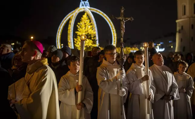 Priests and clergy attend the Christmas celebration midnight Mass at the Cathedral-Basilica in Vilnius, Lithuania, Tuesday, Dec. 24, 2024. (AP Photo/Mindaugas Kulbis)