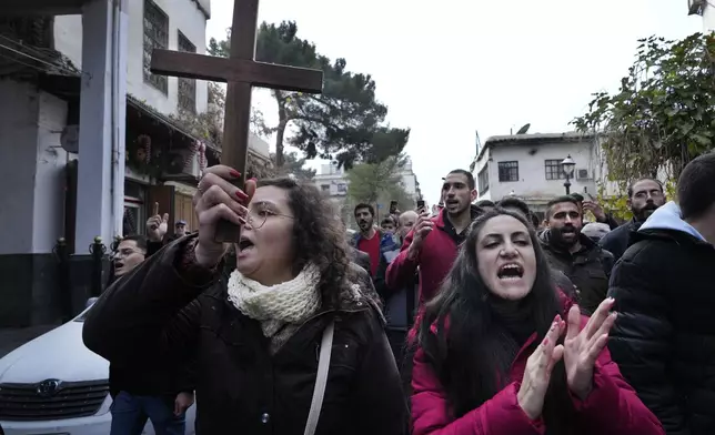 Syrian Christians shout slogans in Damascus, Syria, Tuesday, Dec. 24, 2024, as they march during a protest after a Christmas tree was set on fire in Hamah city on Sunday. (AP Photo/Hussein Malla)