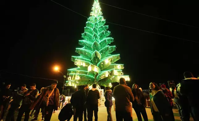 Syrian citizens gather outside Saydnaya Convent during the lighting of the Christmas tree, in Saydnaya town on the outskirts of Damascus, Syria, Tuesday, Dec. 24, 2024. (AP Photo/Hussein Malla)