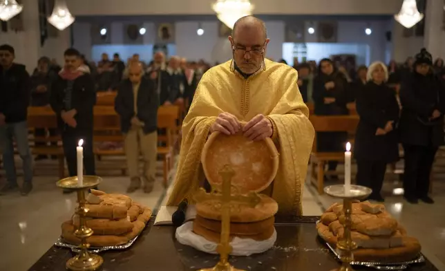 Priest Jalal Ghazal attends a Christmas mass at the church of St. George, in Maaloula, some 60 km northern Damascus, Syria, Tuesday, Dec. 24, 2024. (AP Photo/Leo Correa)