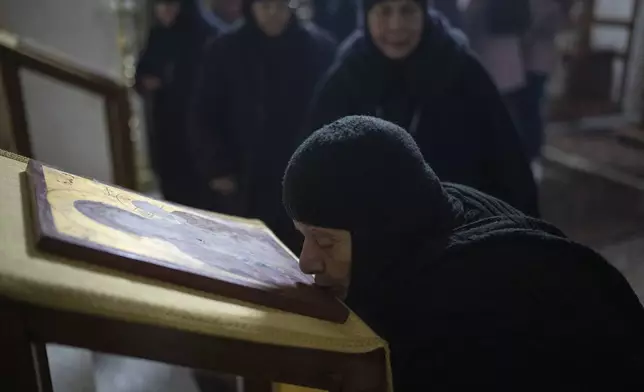 A nun attends the Christmas mass in the Greek Orthodox convent Saint Takla, in Maaloula, some 60 km northern Damascus, Syria, Tuesday, Dec. 24, 2024. (AP Photo/Leo Correa)