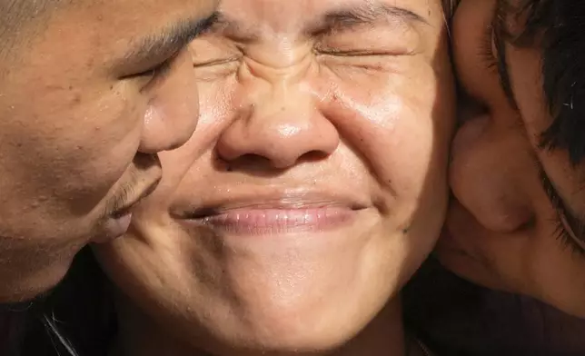 Mary Jane Veloso, center, a Filipino woman who spent almost 15 years in an Indonesian prison for drug trafficking and was nearly executed by firing squad in 2015, is kissed by her sons after being reunited at the Correctional Institution for Women in Mandaluyong, Philippines Wednesday, Dec. 18, 2024. (AP Photo/Aaron Favila)