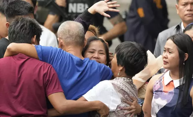 Mary Jane Veloso, center, a Filipino woman who spent almost 15 years in an Indonesian prison for drug trafficking and was nearly executed by firing squad in 2015, waves as she is reunited with her family at the Correctional Institution for Women in Mandaluyong, Philippines on Wednesday, Dec. 18, 2024. (AP Photo/Aaron Favila)