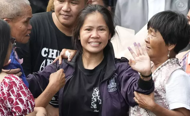 Mary Jane Veloso, center, a Filipino woman who spent almost 15 years in an Indonesian prison for drug trafficking and was nearly executed by firing squad in 2015, waves as she is reunited with her family at the Correctional Institution for Women in Mandaluyong, Philippines on Wednesday, Dec. 18, 2024. (AP Photo/Aaron Favila)