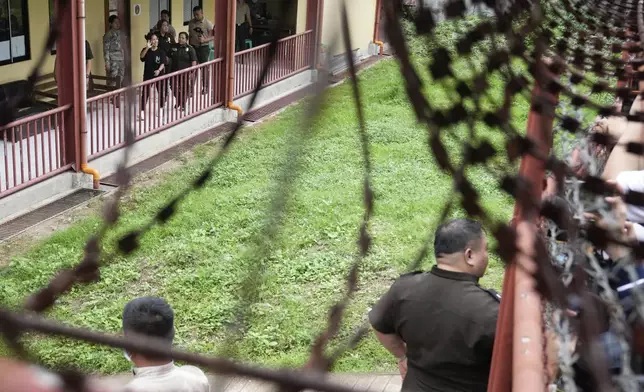 Mary Jane Veloso, a Filipino woman who spent almost 15 years in an Indonesian prison for drug trafficking and was nearly executed by firing squad in 2015, waves to reporters as she is processed at the Correctional Institution for Women in Mandaluyong, Philippines Wednesday, Dec. 18, 2024. (AP Photo/Aaron Favila)