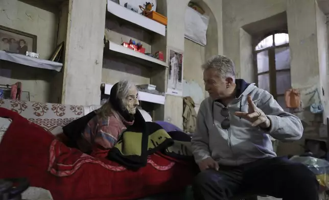 Bakhour Chamantoub, 74, left, the head of the Jewish community in Syria and one of the people who refused to leave Syria despite opportunities abroad and the nearly 14-year-old war, speaks with a Syrian-Jew old woman Firdos Mallakh, 86, at her home in Damascus, Syria, Thursday, Dec. 26, 2024. (AP Photo/Omar Sanadiki)