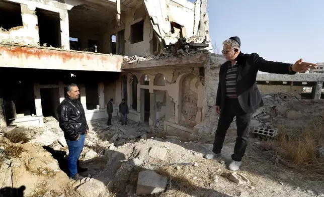 Bakhour Chamantoub, 74, right, the head of the Jewish community in Syria and one of the people who refused to leave Syria despite opportunities abroad and the nearly 14-year-old war, speaks with a Syrian man during his visit to the destroyed Jobar Synagogue, also known as Eliyahu Hanavi, in Jobar neighborhood, in Damascus, Syria, Thursday, Dec. 26, 2024. (AP Photo/Omar Sanadiki)