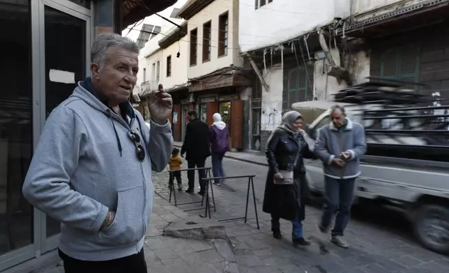 Bakhour Chamantoub, 74, left, the head of the Jewish community in Syria and one of the people who refused to leave Syria despite opportunities abroad and the nearly 14-year-old war, stands outside his house in Damascus, Syria, Thursday, Dec. 26, 2024. (AP Photo/Omar Sanadiki)