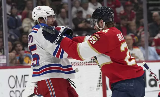 Florida Panthers defenseman Uvis Balinskis, right, pushes New York Rangers left wing Brett Berard during the first period of an NHL hockey game, Monday, Dec. 30, 2024, in Sunrise, Fla. (AP Photo/Lynne Sladky)