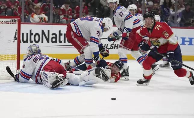 Florida Panthers center Jesper Boqvist (70) goes for the puck before scoring a goal against New York Rangers goaltender Igor Shesterkin (31) during the second period of an NHL hockey game Monday, Dec. 30, 2024, in Sunrise, Fla. (AP Photo/Lynne Sladky)