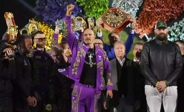 Boxers Britain's Tyson Fury, right, and world champion Ukraine's Oleksandr Usyk, center, stand on stage during the weigh-in for their WBA, WBO, and WBC heavyweight title bout in Riyadh, Saudi Arabia, Friday, Dec. 20, 2024. (AP Photo/Frank Augstein)