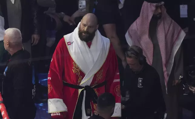 Boxers Britain's Tyson Fury walks to the ring before facing Ukraine's Oleksandr Usyk in their WBA, WBO, and WBC world heavyweight title fight in Riyadh, Saudi Arabia, Saturday, Dec. 21, 2024. (AP Photo/Frank Augstein)