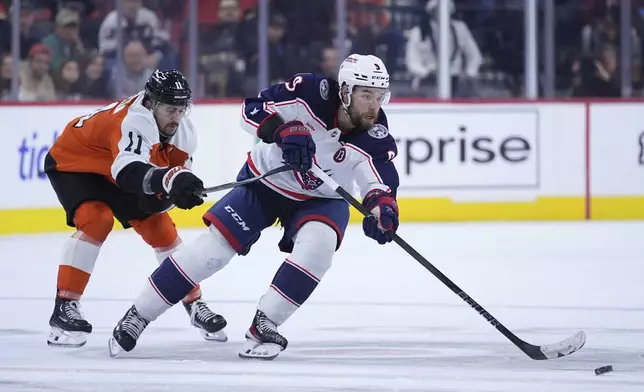 Columbus Blue Jackets' Ivan Provorov, right, tries to keep the puck away from Philadelphia Flyers' Travis Konecny during the third period of an NHL hockey game, Saturday, Dec. 21, 2024, in Philadelphia. (AP Photo/Matt Slocum)