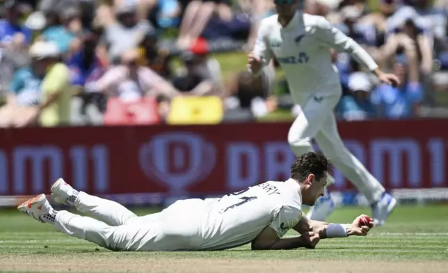 New Zealand's Matt Henry takes a catch off his own bowling to dismiss England's Zak Crawley during play on day two of the third cricket test between England and New Zealand in Hamilton, New Zealand, Sunday, Dec. 15, 2024. (Andrew Cornaga/Photosport via AP)