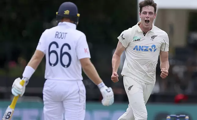New Zealand bowler Will O'Rourke celebrates the wicket of England batsman Joe Root, left, during play on day two of the third cricket test between England and New Zealand in Hamilton, New Zealand, Sunday, Dec. 15, 2024. (Bruce Lim/Photosport via AP)