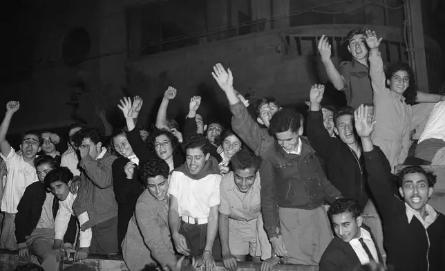 FILE - Jewish people wave and cheer as they gather in the streets of Tel Aviv after radio broadcasts announce that the United Nations plans for the partition of Palestine and the new Jewish state, Nov. 30, 1947. (AP Photo/Jim Pringle, File)