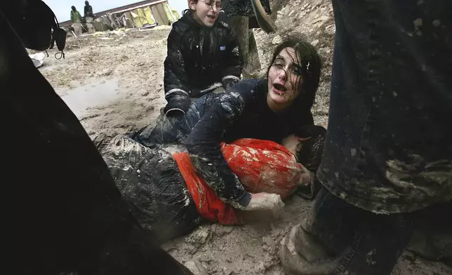 FILE - Israeli settler girls cry in the mud after being dragged away by Israeli army soldiers dismantling an illegal structure at an outpost outside the Jewish settlement of Yitzhar, near the West Bank town of Nablus, Jan. 3, 2005. (AP Photo/Kevin Frayer, File)