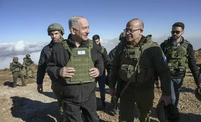 Israel's Prime Minister Benjamin Netanyahu, left, visits Israeli forces in a buffer zone inside Syria, Tuesday, Dec. 17, 2024. (Israel Government Press Office via AP)