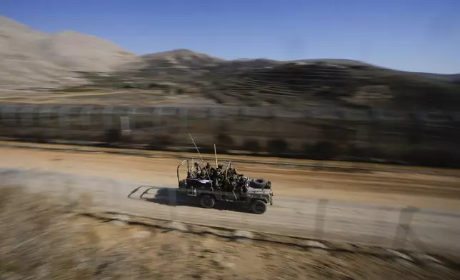 Israeli soldiers stand on an armored vehicle after crossing the security fence along the so-called Alpha Line that separates the Israeli-controlled Golan Heights from Syria, in the town of Majdal Shams, Tuesday, Dec. 17, 2024. (AP Photo/Matias Delacroix)