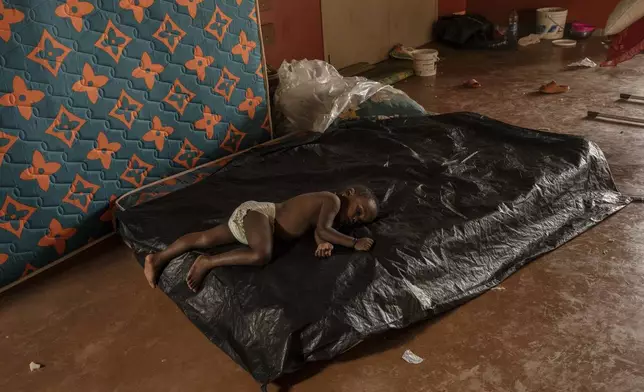 A child sleeps at the Lycée des Lumières where he found refuge, Thursday, Dec. 19, 2024 in Mamoudzou, Mayotte, (AP Photo/Adrienne Surprenant)