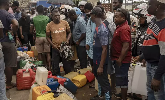 People queue for gas in Mamoudzou, in the French Indian Ocean island of Mayotte, Thursday, Dec. 19, 2024, after Cyclone Chido. (AP Photo/Adrienne Surprenant)