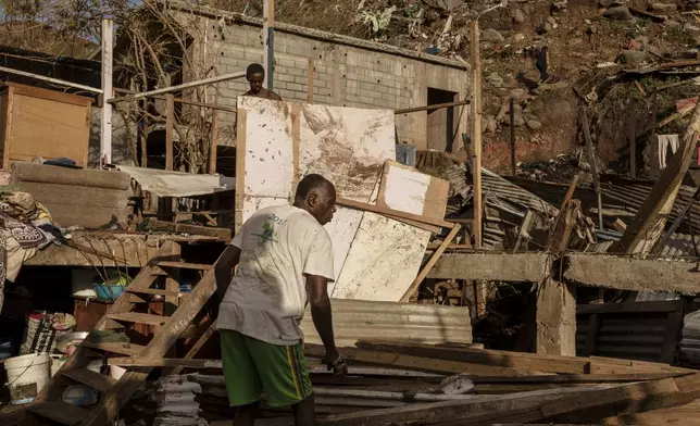 A man starts rebuilding his shack in the Kaweni slum on the outskirts of Mamoudzou, in the French Indian Ocean island of Mayotte, Thursday, Dec. 19, 2024, after Cyclone Chido. (AP Photo/Adrienne Surprenant)