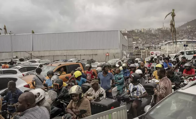 People queue for gas in Mamoudzou, in the French Indian Ocean island of Mayotte, Thursday, Dec. 19, 2024, after Cyclone Chido. (AP Photo/Adrienne Surprenant)