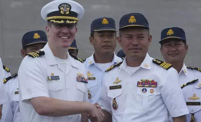 Daniel A. Sledz, left, commanding officer of USS Savannah, shakes hands with Cambodian Deputy Commander of Ream Naval Base, Capt. Mean Savoeun, front right, as it arrives for a port call at Sihanoukville port, Cambodia, Monday, Dec. 16, 2024. (AP Photo/Heng Sinith)