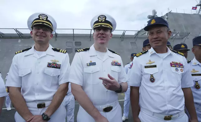 Daniel A. Sledz, center, commanding officer of USS Savannah, meets with Cambodian Deputy Commander of Ream Naval Base, Capt. Mean Savoeun, right, as it arrives for a port call at Sihanoukville port, Cambodia, Monday, Dec. 16, 2024. (AP Photo/Heng Sinith)