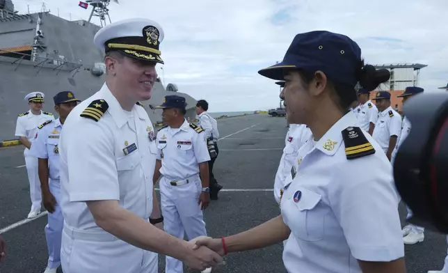 Daniel A. Sledz, left, commanding officer of USS Savannah, shakes hands with a Cambodian naval staff member as it arrives for a port call at Sihanoukville port, Cambodia, Monday, Dec. 16, 2024. (AP Photo/Heng Sinith)