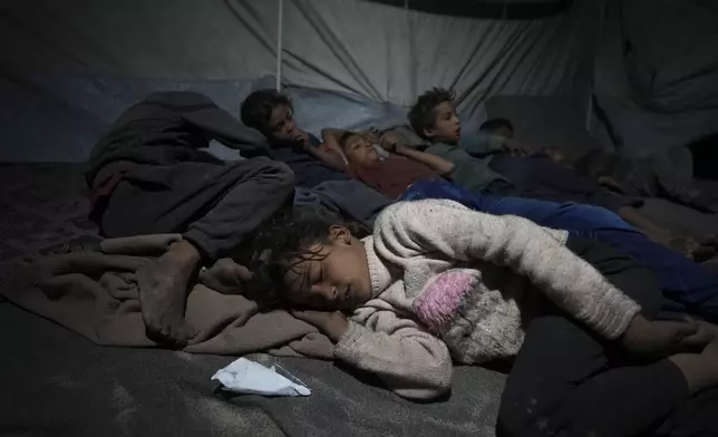 Shireen Daifallah's children, who were displaced from northern Gaza, sleep in their tent at a camp for displaced people in Deir al-Balah. Gaza Strip, Saturday, Nov. 30, 2024. (AP Photo/Abdel Kareem Hana)