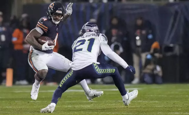 Chicago Bears running back D'Andre Swift, left, runs with the ball as Seattle Seahawks cornerback Devon Witherspoon defends during the second half of an NFL football game, Thursday, Dec. 26, 2024, in Chicago. (AP Photo/Nam Y. Huh)