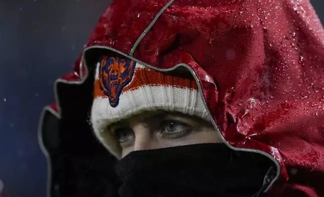 A spectator braves the rain to watch the second half of an NFL football game between the Chicago Bears and the Seattle Seahawks, Thursday, Dec. 26, 2024, in Chicago. (AP Photo/Nam Y. Huh)