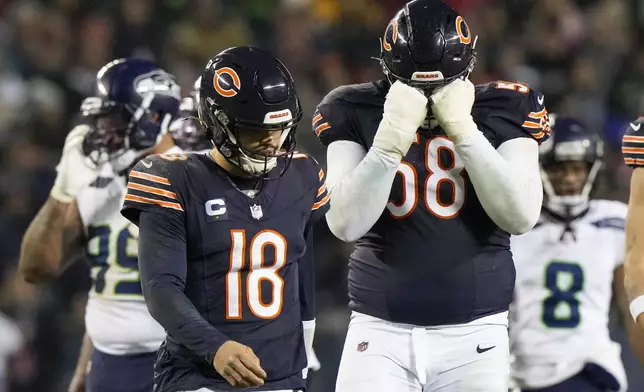 Chicago Bears quarterback Caleb Williams (18) and offensive tackle Darnell Wright (58) react while walking off the field during the second half of an NFL football game against the Seattle Seahawks, Thursday, Dec. 26, 2024, in Chicago. The Seahawks won 6-3. (AP Photo/Nam Y. Huh)