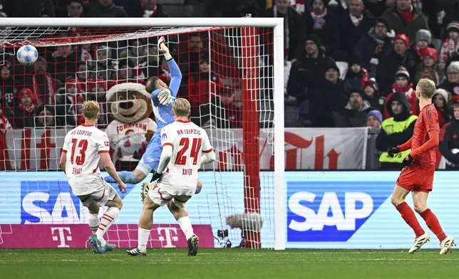 Munich's Konrad Laimer, right, scores during the Bundesliga soccer match between Bayern Munich and RB Leipzig at the Allianz Arena, Munich, Germany, Friday Dec. 20, 2024. (Tom Weller/dpa via AP)