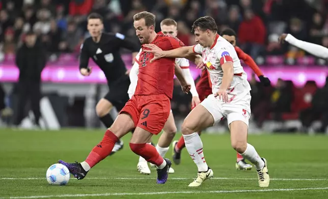 Munich's Harry Kane, left, and Leipzig's Willi Orban in action during the Bundesliga soccer match between Bayern Munich and RB Leipzig at the Allianz Arena, Munich, Germany, Friday Dec. 20, 2024. (Sven Hoppe/dpa via AP)