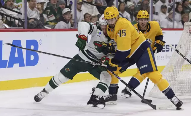 Nashville Predators defenseman Alexandre Carrier (45) hits Minnesota Wild left wing Kirill Kaprizov, left, during the first period of an NHL hockey game Saturday, Nov. 30, 2024, in St. Paul, Minn. (AP Photo/Bailey Hillesheim)