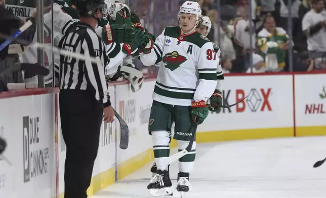 Minnesota Wild left wing Kirill Kaprizov (97) is congratulated by teammates after scoring a goal during the second period of an NHL hockey game against the Nashville Predators, Saturday, Nov. 30, 2024, in St. Paul, Minn. (AP Photo/Bailey Hillesheim)