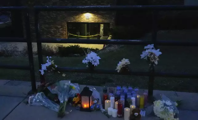 Flowers and candles are placed outside the Abundant Life Christian School Tuesday, Dec. 17, 2024 in Madison, Wis., following a shooting on Monday. (AP Photo/Nam Y. Huh)