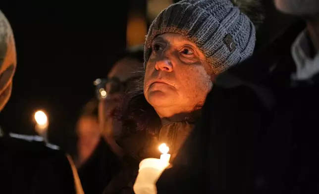 Supporters hold candles during a candlelight vigil Tuesday, Dec. 17, 2024, outside the Wisconsin Capitol in Madison, Wis., following a shooting at the Abundant Life Christian School on Monday, Dec. 16. (AP Photo/Morry Gash)