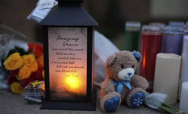 Flowers and candles are placed outside the Abundant Life Christian School Tuesday, Dec. 17, 2024 in Madison, Wis., following a shooting on Monday. (AP Photo/Nam Y. Huh)