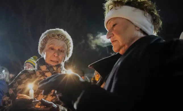 Supporters hold candles during a candlelight vigil Tuesday, Dec. 17, 2024, outside the Wisconsin Capitol in Madison, Wis., following a shooting at the Abundant Life Christian School on Monday, Dec. 16. (AP Photo/Morry Gash)