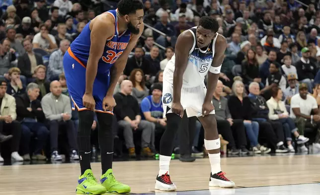 New York Knicks center Karl-Anthony Towns (32) and Minnesota Timberwolves guard Anthony Edwards (5) talk during the first half of an NBA basketball game, Thursday, Dec. 19, 2024, in Minneapolis. (AP Photo/Abbie Parr)