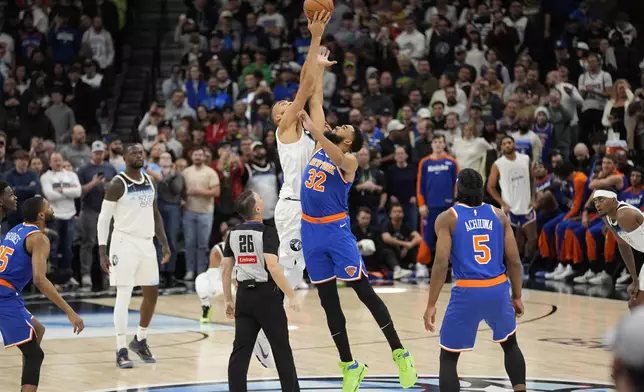 Minnesota Timberwolves center Rudy Gobert (27) and New York Knicks center Karl-Anthony Towns (32) jump during the tip-off in the first half of an NBA basketball game, Thursday, Dec. 19, 2024, in Minneapolis. (AP Photo/Abbie Parr)