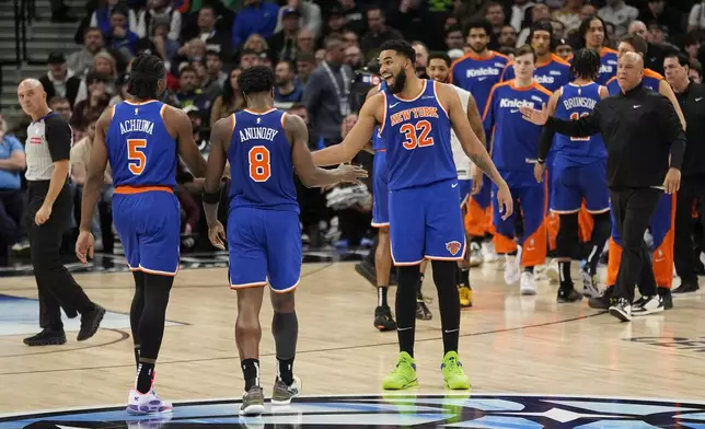 New York Knicks center Karl-Anthony Towns (32) celebrates with teammates after a timeout called in the second half of an NBA basketball game against the Minnesota Timberwolves, Thursday, Dec. 19, 2024, in Minneapolis. (AP Photo/Abbie Parr)