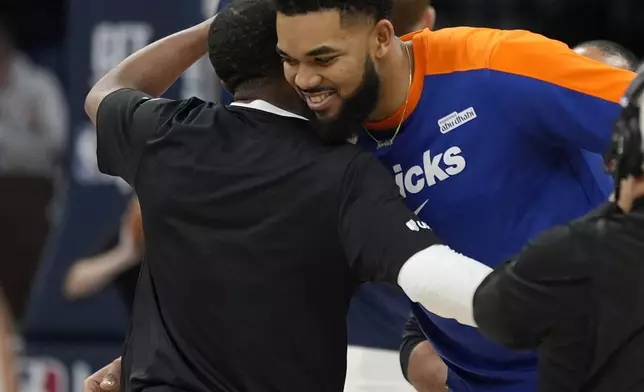 Minnesota Timberwolves guard Mike Conley, left, and New York Knicks center Karl-Anthony Towns, right, hug before an NBA basketball game Thursday, Dec. 19, 2024, in Minneapolis. (AP Photo/Abbie Parr)