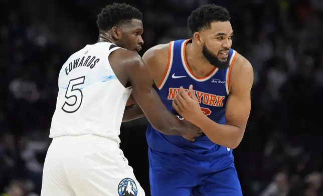 New York Knicks center Karl-Anthony Towns (32) is guarded by Minnesota Timberwolves guard Anthony Edwards (5) during the second half of an NBA basketball game, Thursday, Dec. 19, 2024, in Minneapolis. (AP Photo/Abbie Parr)