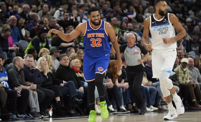 New York Knicks center Karl-Anthony Towns (32) celebrates after making a 3-point basket over Minnesota Timberwolves center Rudy Gobert (27) during the first half of an NBA basketball game, Thursday, Dec. 19, 2024, in Minneapolis. (AP Photo/Abbie Parr)