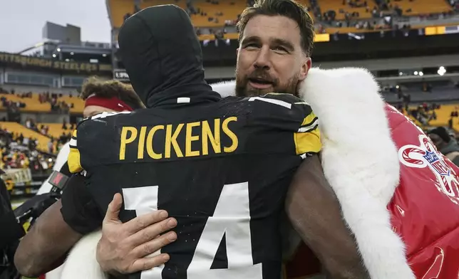 Kansas City Chiefs tight end Travis Kelce (87) and Pittsburgh Steelers wide receiver George Pickens (14) embrace after an NFL football game, Wednesday, Dec. 25, 2024, in Pittsburgh. (AP Photo/Matt Freed)